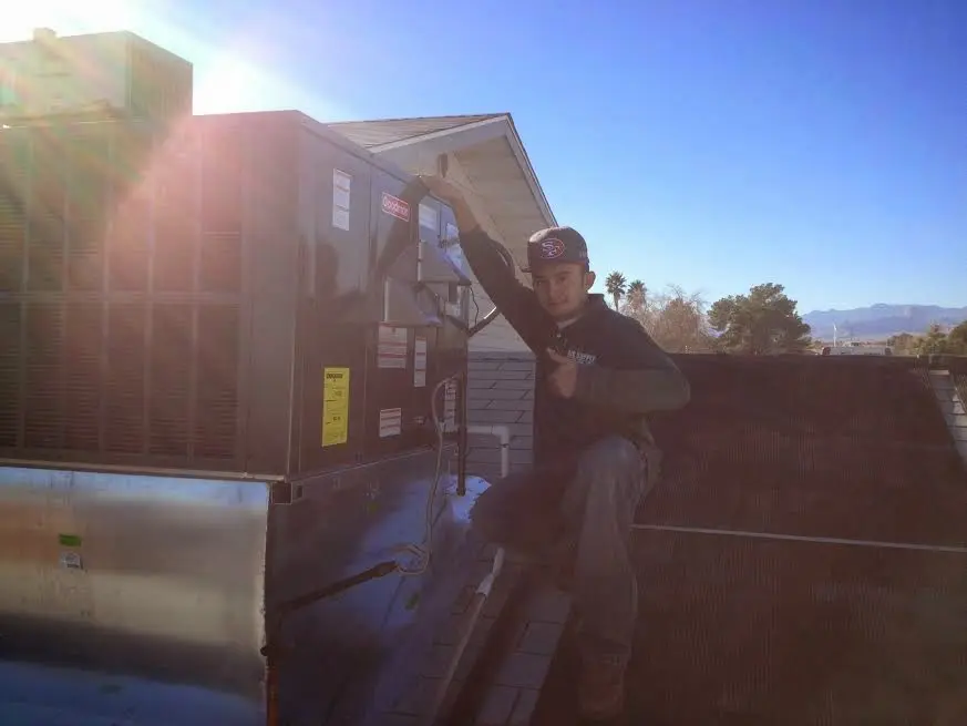 HVAC technician performing Air Duct Repair on a rooftop unit in Dickson